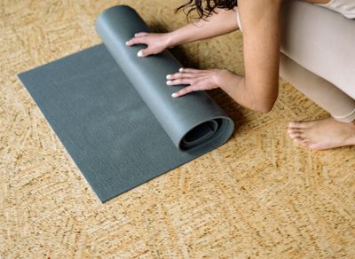 Yoga mat rolled out on a wooden floor.
